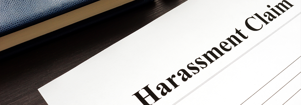 Harassment Claim and pen on a wooden desk