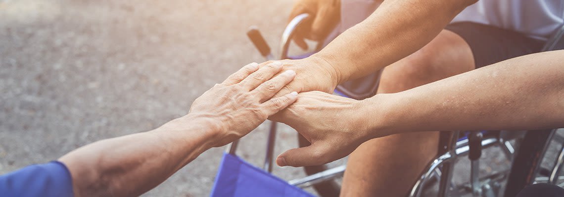 A team of wheelchair users puts their hands in on a huddle