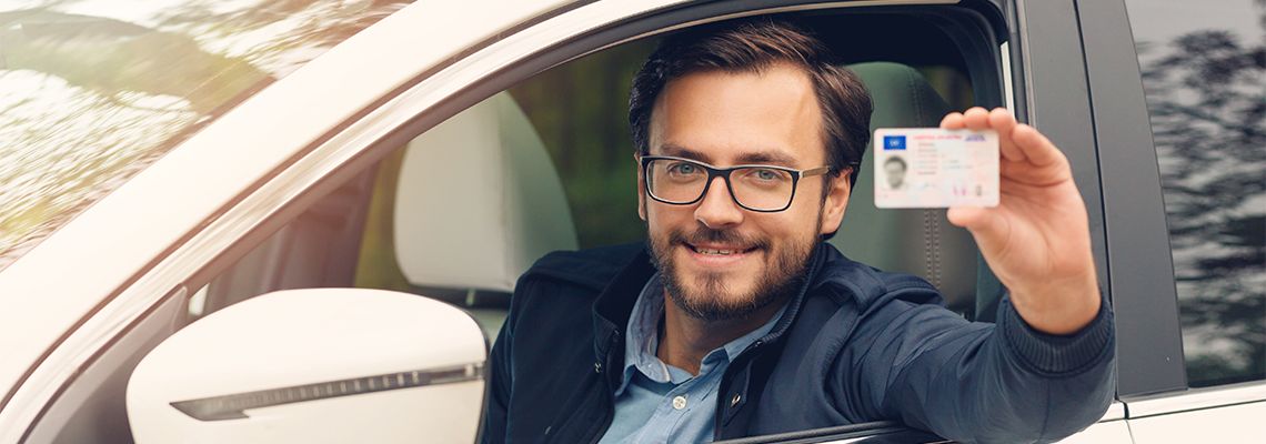 Man with drivers license in hand