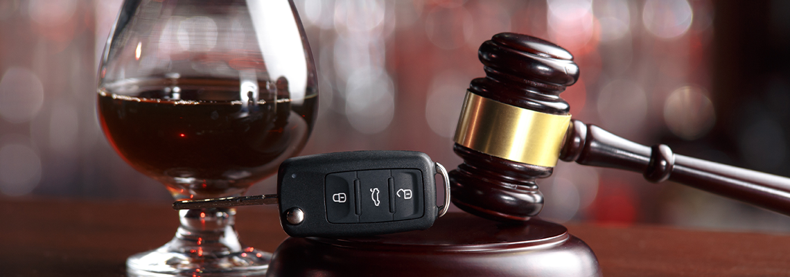 Gavel, alcohol and car keys on wooden table
