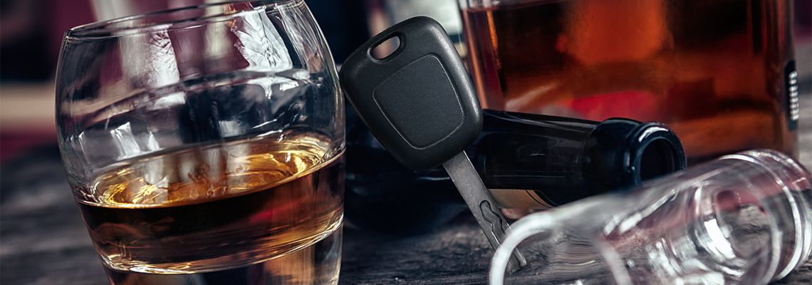 Car Keys and Glass of Alcohol in table