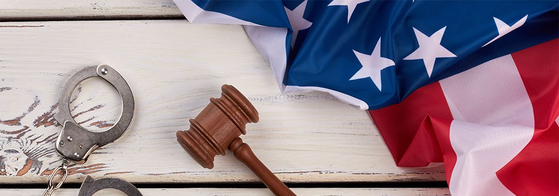 Handcuffs, wooden gavel and USA flag