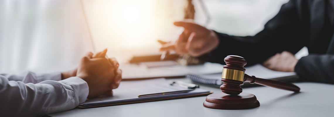 A male judge in the courtroom on a wooden table and a male counselor