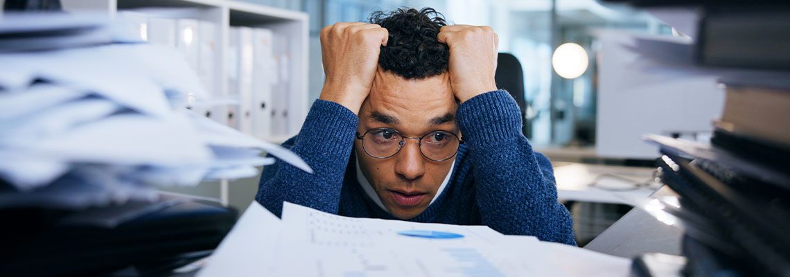 Frustrated employee buried under file