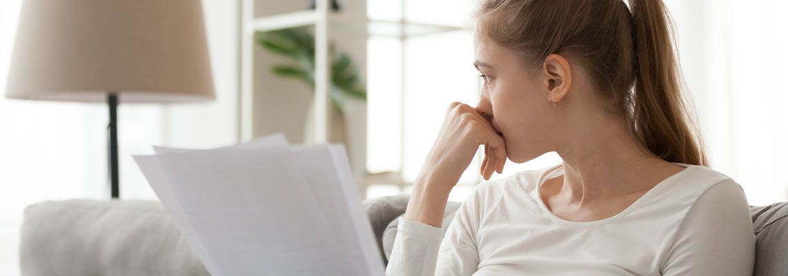 Upset thoughtful woman holding paper document in hands