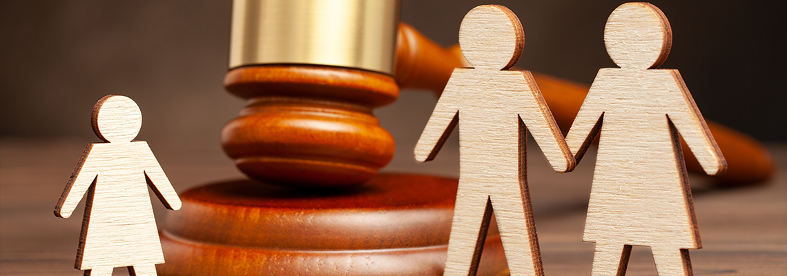 Wooden cutouts of a family separated by a judge's gavel