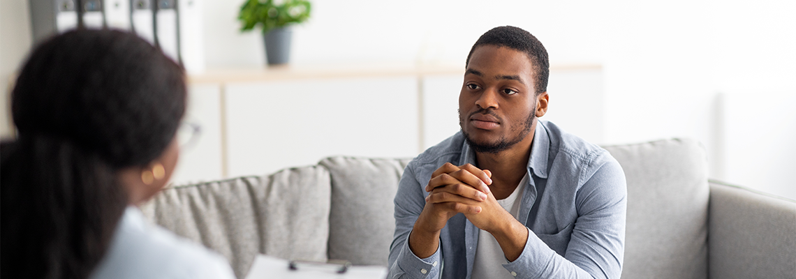 Depressed Male Patient Having Psychotherapy Session with Counselor