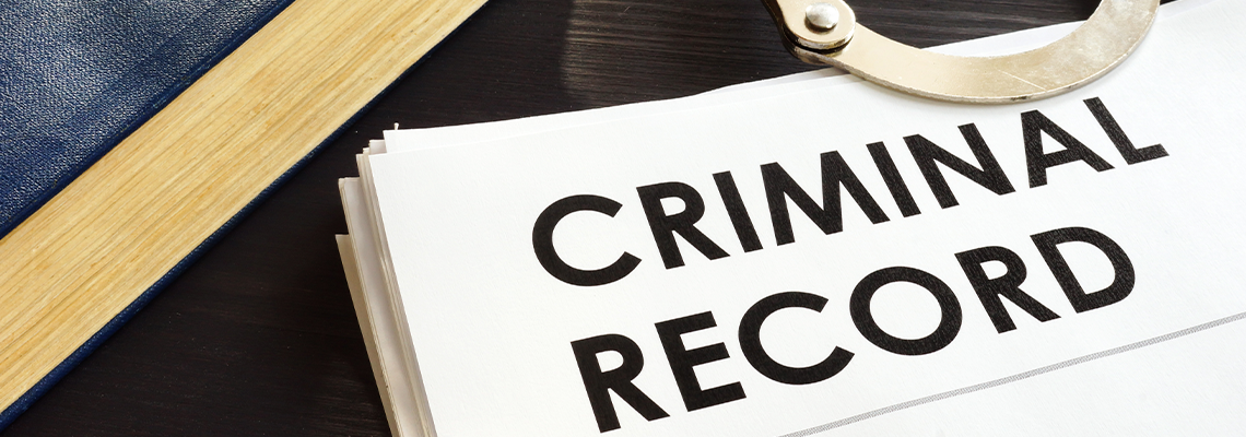 Criminal record and handcuffs on a desk