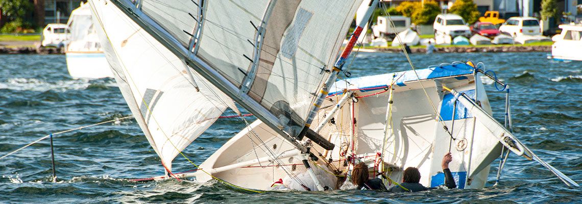 People hanging into turned over boat