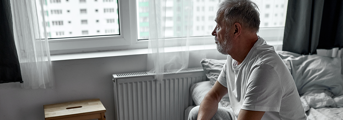 Elderly man sitting alone at home, social distancing and self isolation