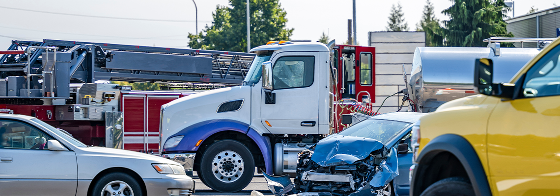 Intersection accident involving a car and a big rig semi truck with tank semi trailer
