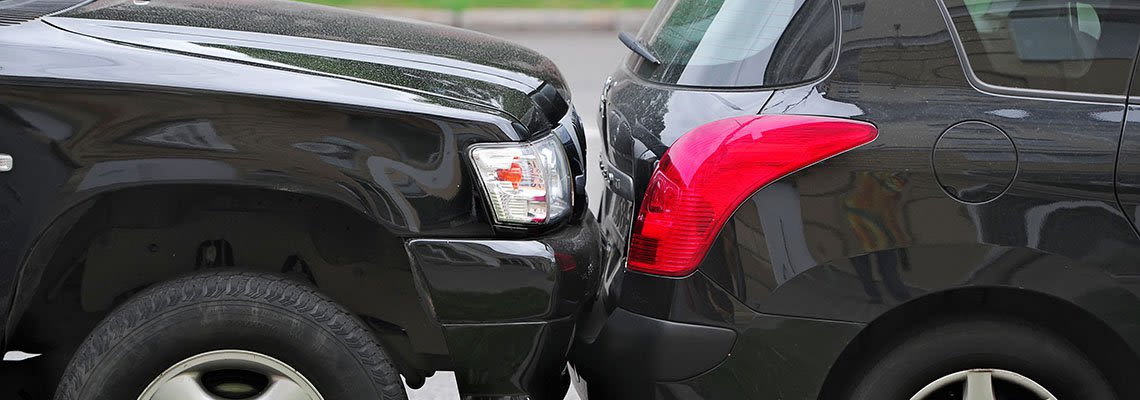 Truck hitting the bumper of a small car