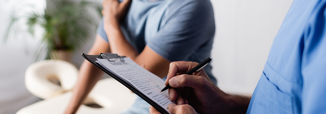 Man holding shoulder in a doctors office