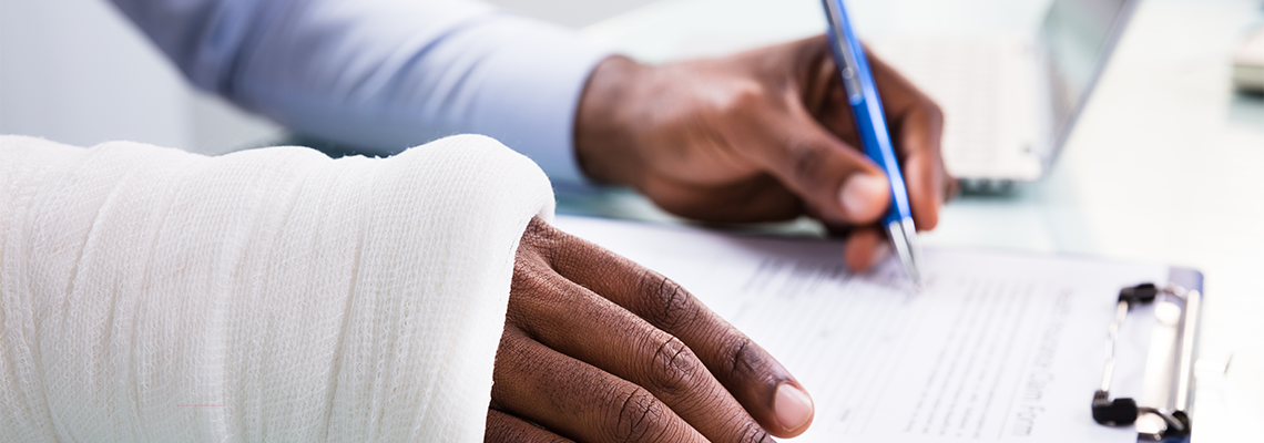 Injured Man Filling Insurance Claim Form