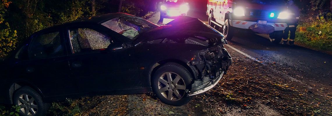 Totaled car in ditch on the side of the road