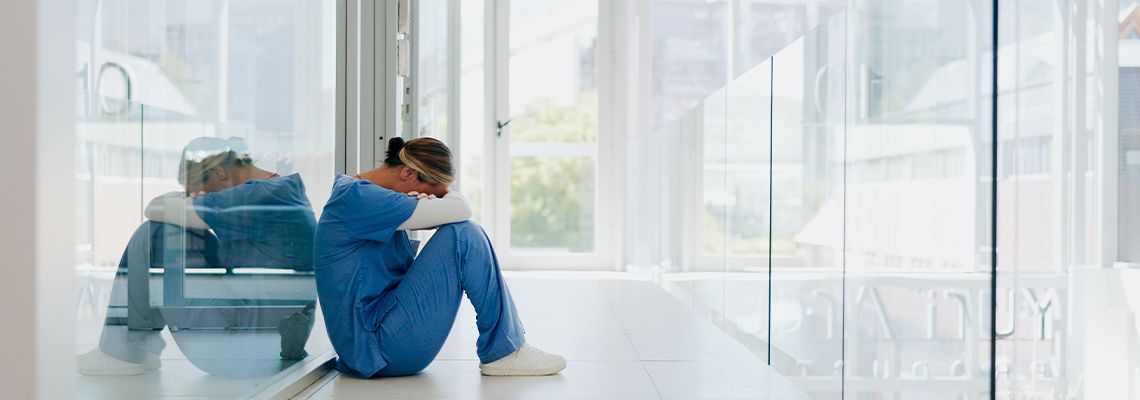 Stressed Nurse sitting on floor