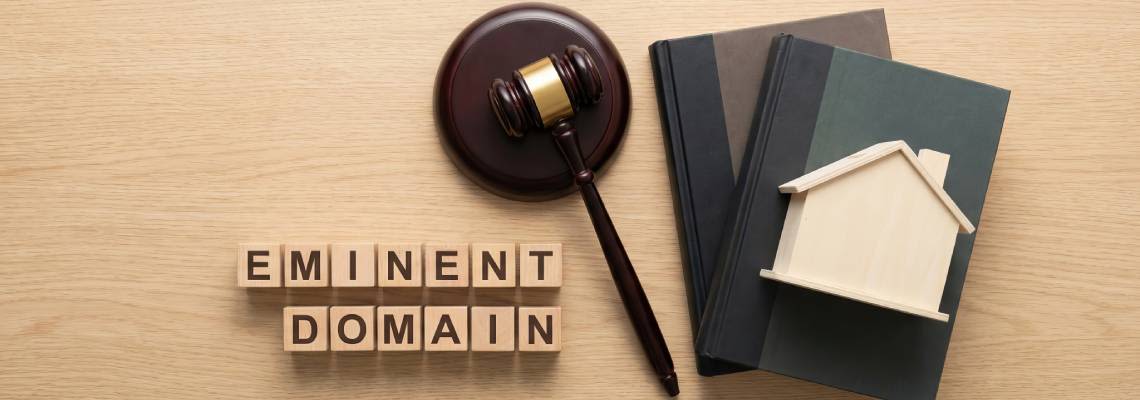 Wooden blocks spelling 'Eminent Domain' with gavel and miniature house