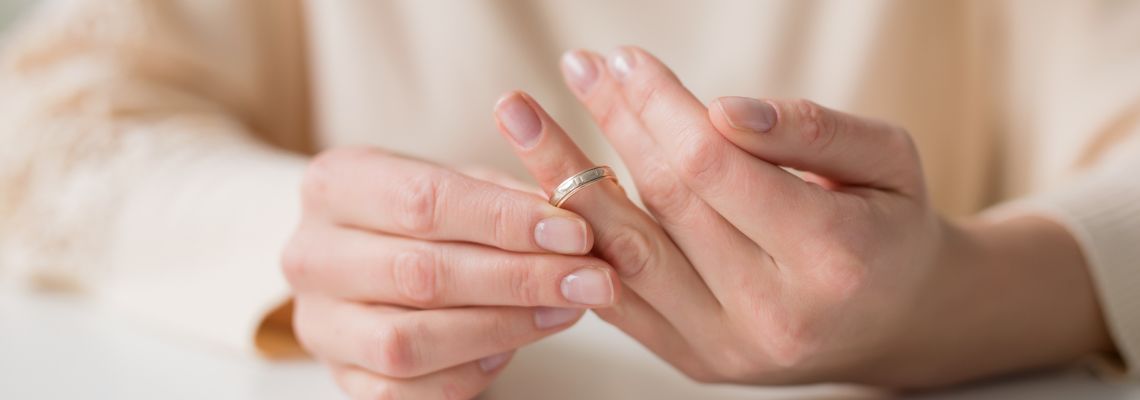 Women removing wedding ring from hand