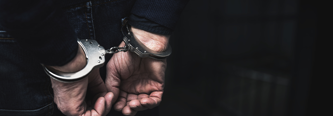 Handcuffed Arrested Man Behind Prison Bars