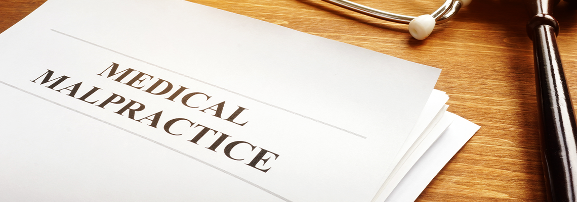 Medical malpractice report and stethoscope and gavel on table