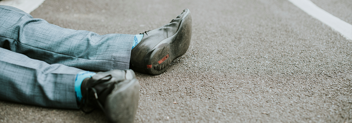 Person lying on the ground after a car accident
