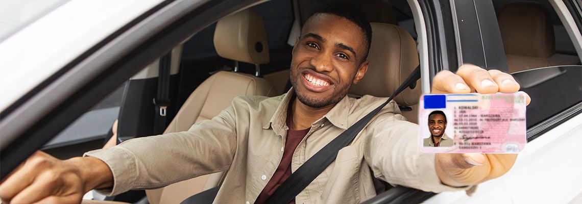 Man showing driving license from car window