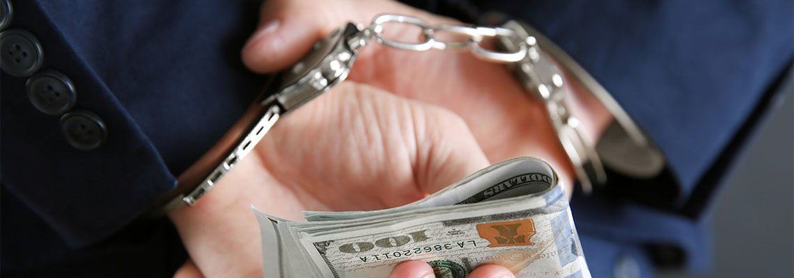Handcuffed businessman with money in hand