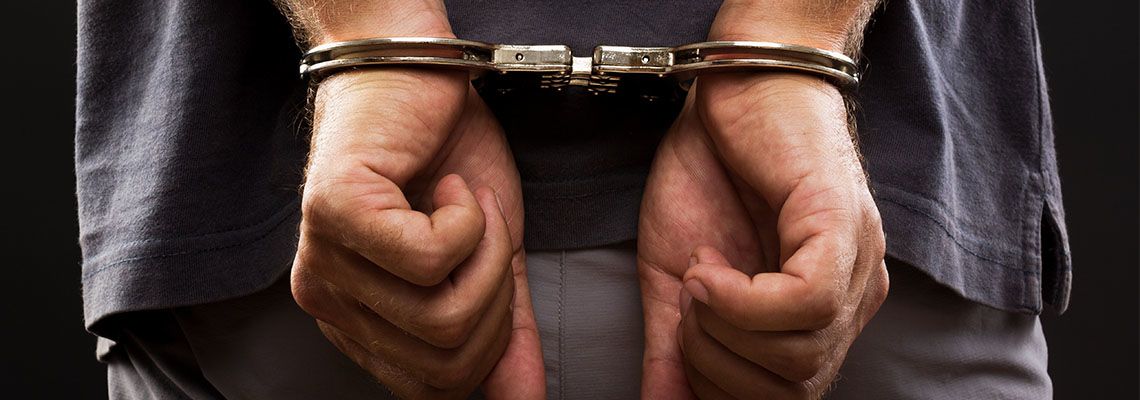 Handcuffed hands of a man behind his back