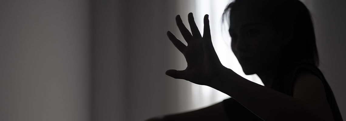 Women in dark showing hands signaling to stop sexual crime