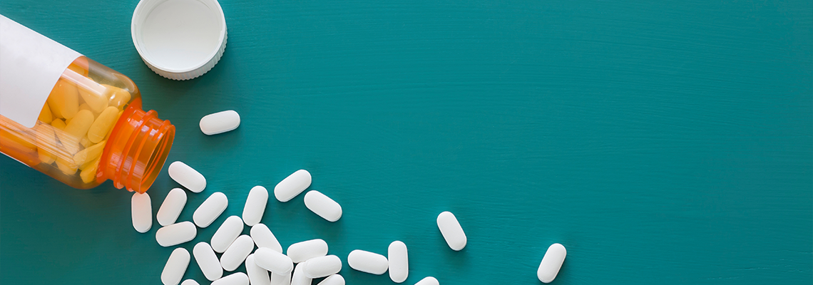White Pills on a Teal Background