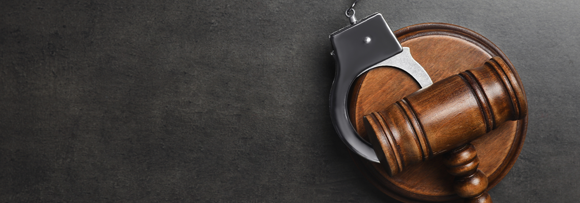 Judge's gavel and handcuffs on grey background, flat lay with space for text