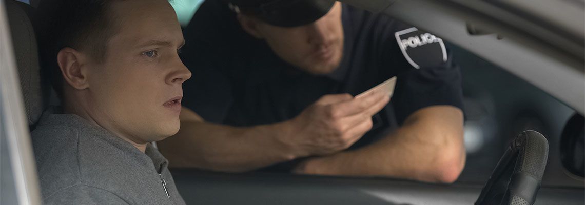 Police officer checking driver's license of a worried man