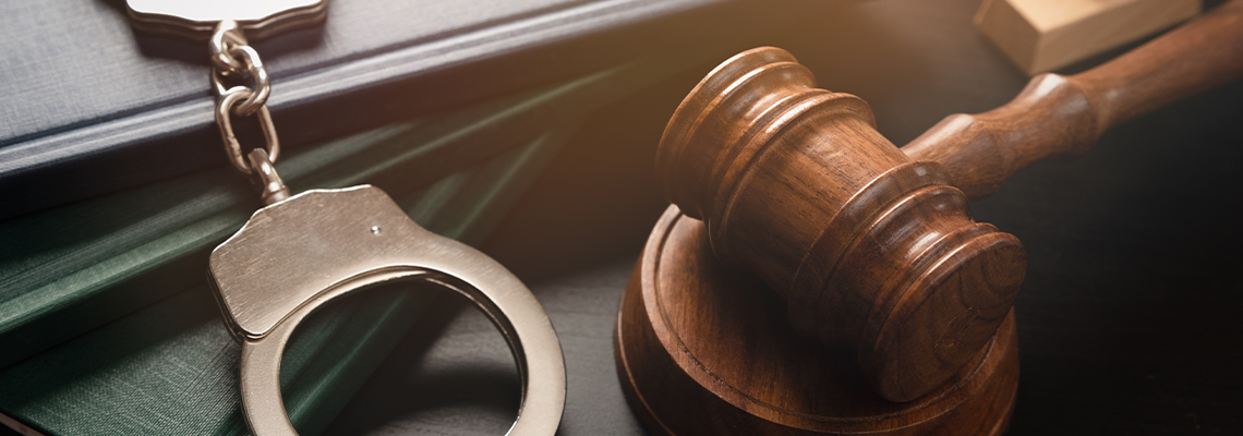 Metal handcuffs near judge gavel