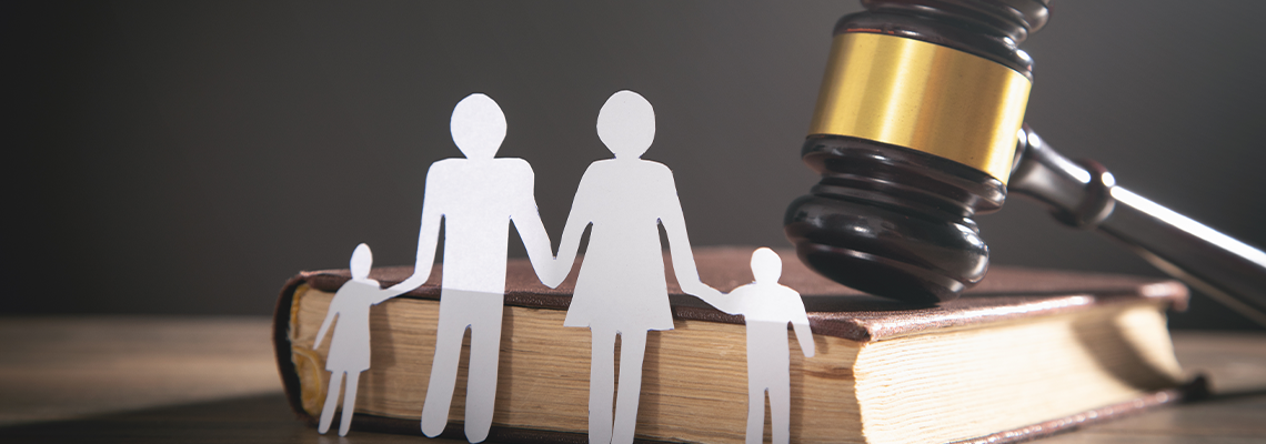 Paper cutout of figures on desk with book and gavel