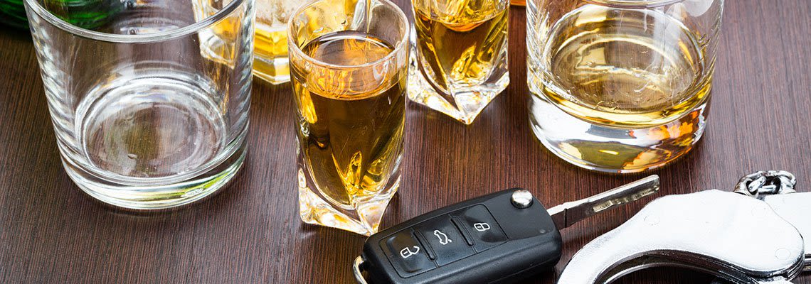 Glasses with alcohol with keys sitting next to them
