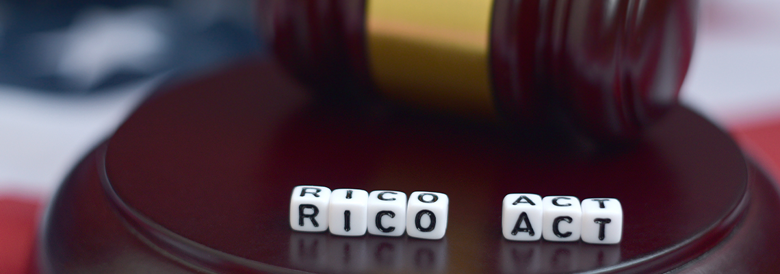 Justice mallet and RICO act acronym with US flag on background