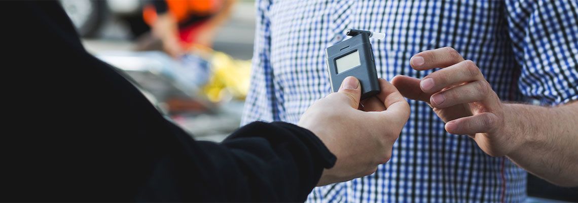 Policeman giving a breathalyzer to a driver