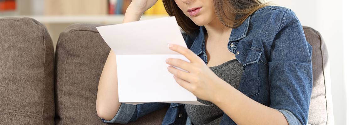 Concerned woman reading bad news in a letter.