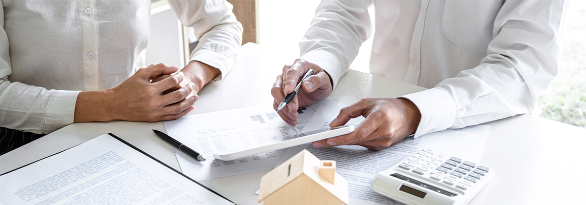 Two people sitting at desk looking at paperwork