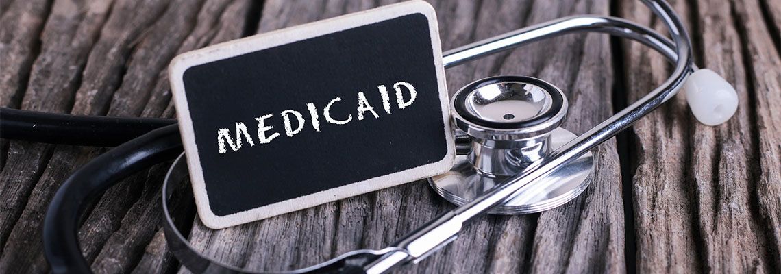 Blackboard with word MEDICAID and stethoscope
