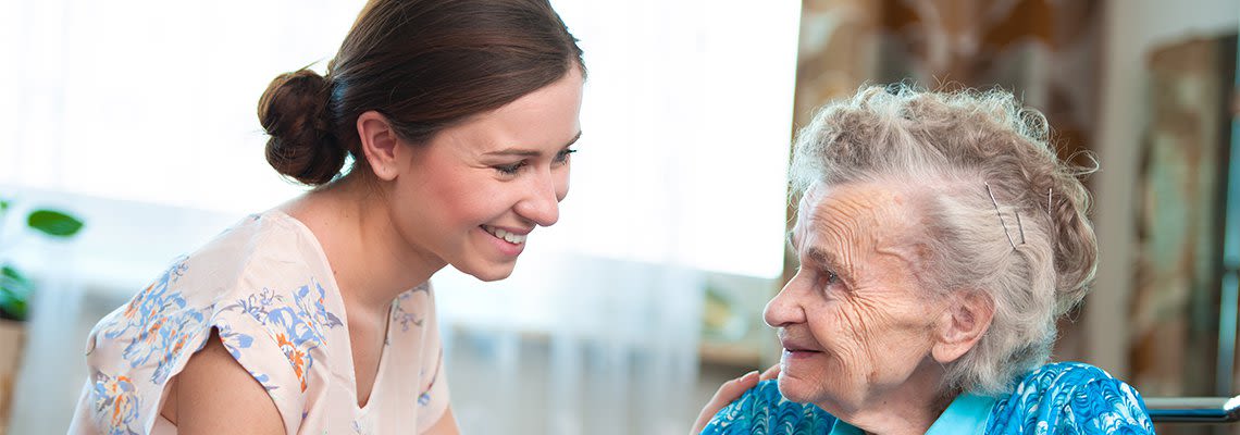 Adult placing their hand on an elderly person