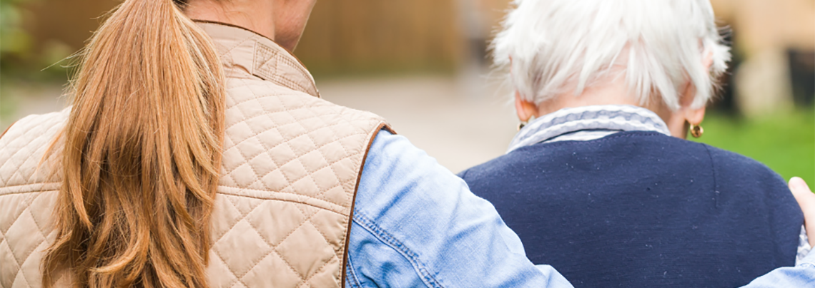 Woman with her arm around an elderly man