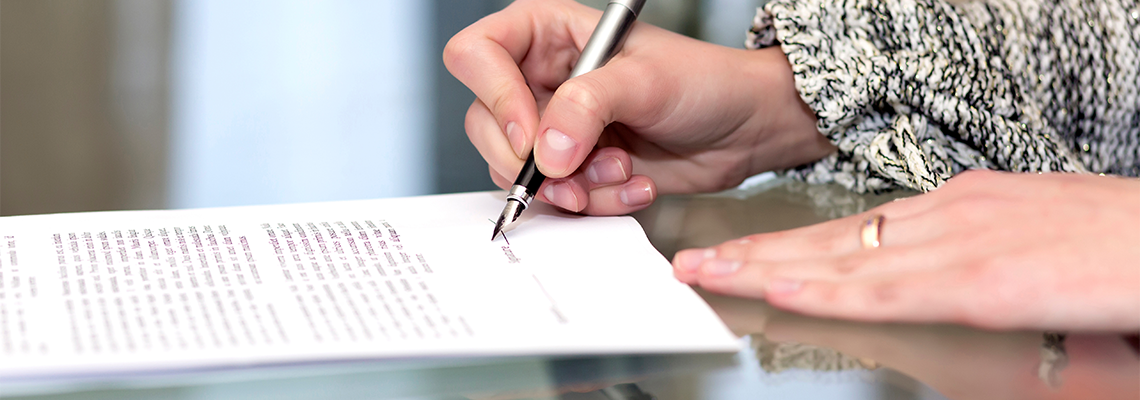 Close up of female hand signing formal paper
