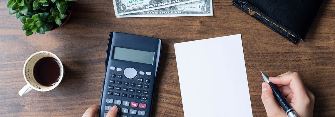 Person_writing_at_desk_with_calcu.2e16d0ba.fill-1140x400