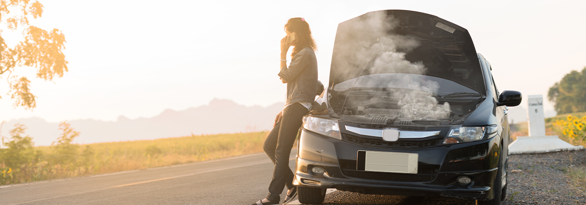 Person standing next to broken down car