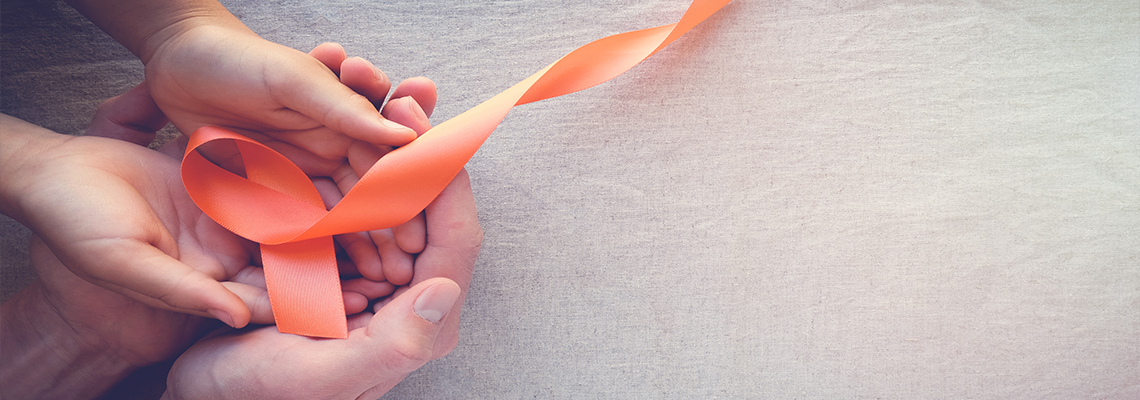 Adult and child hands holding orange ribbon