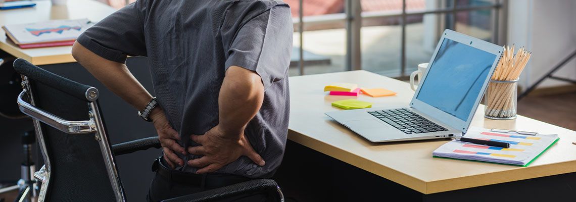 Man feeling back pain at office