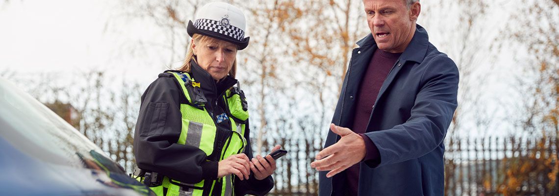 Police Officer Taking Witness Statement From Driver After Traffic Accident