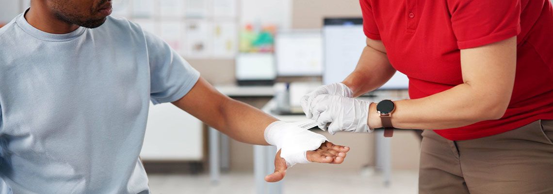 Medical person applying bandage to burnt hand of a man