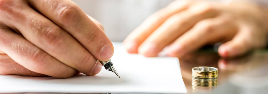 Hands signing divorce papers